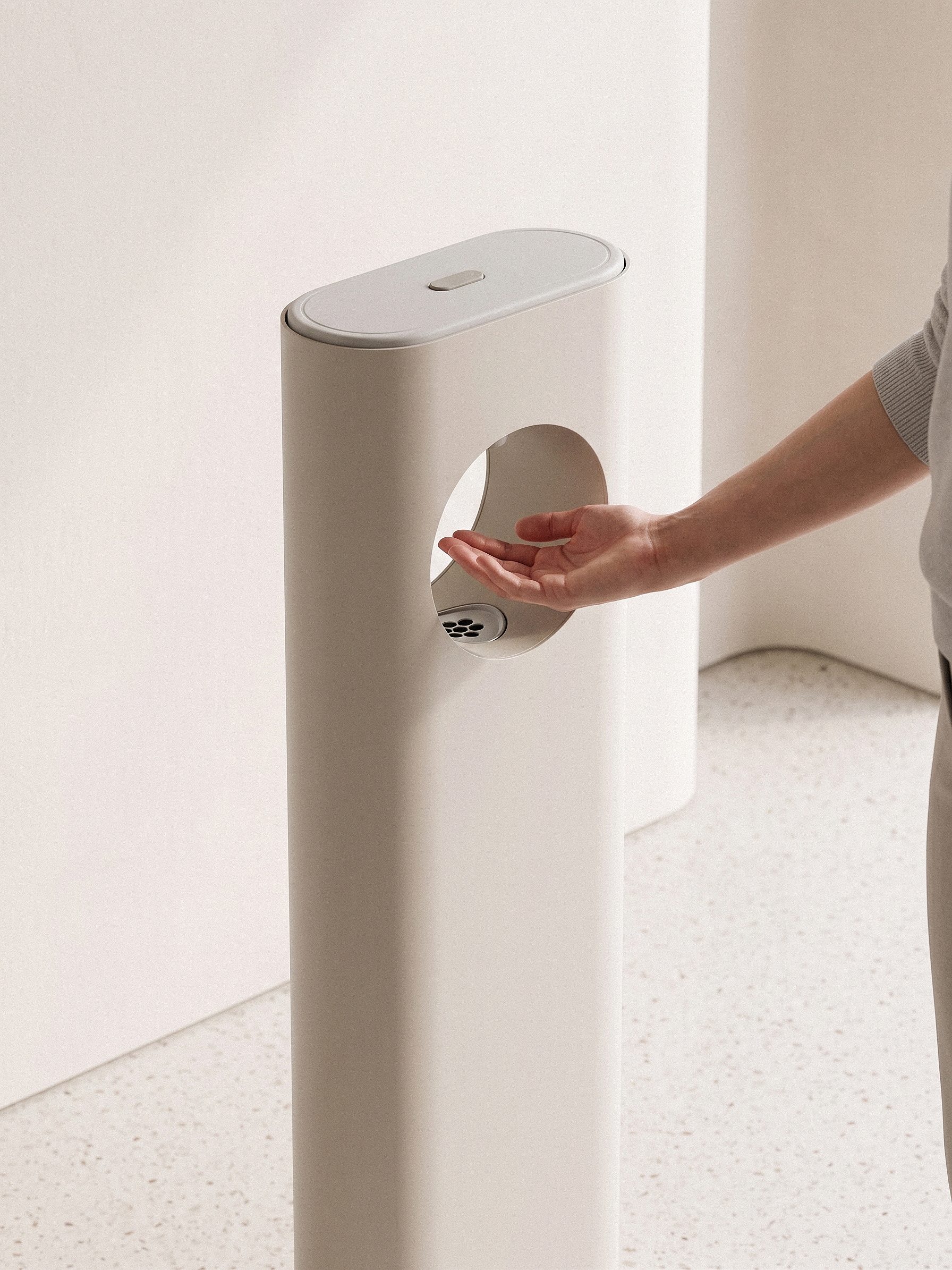 A hand held open beneath the dispenser's ring opening, sunscreen nozzle above the palm